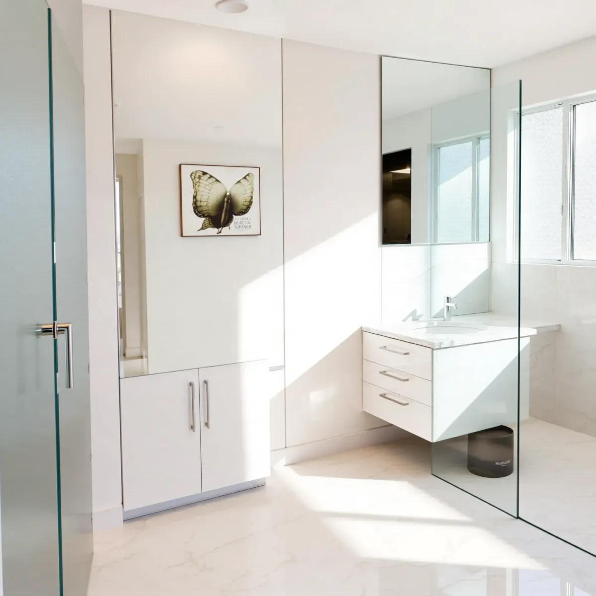 Remodeled Crenshaw bathroom with marble countertops, glass shower, modern fixtures, polished tiles, and natural light.