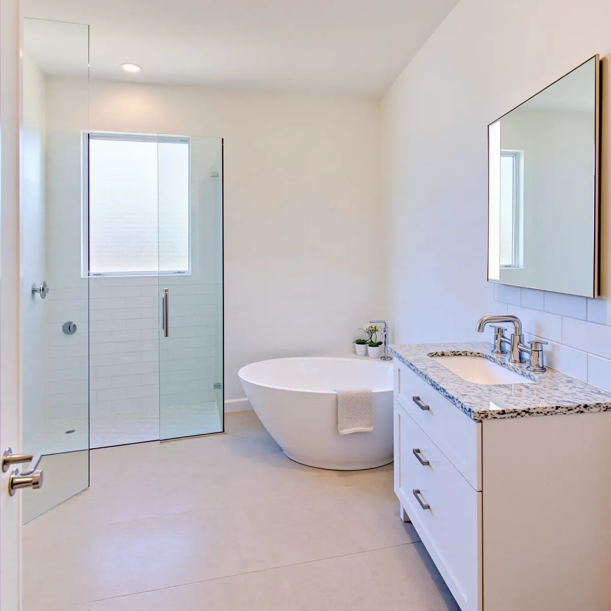 Remodeled Westchester bathroom with modern fixtures, marble tiles, glass shower, and coastal-inspired decor.