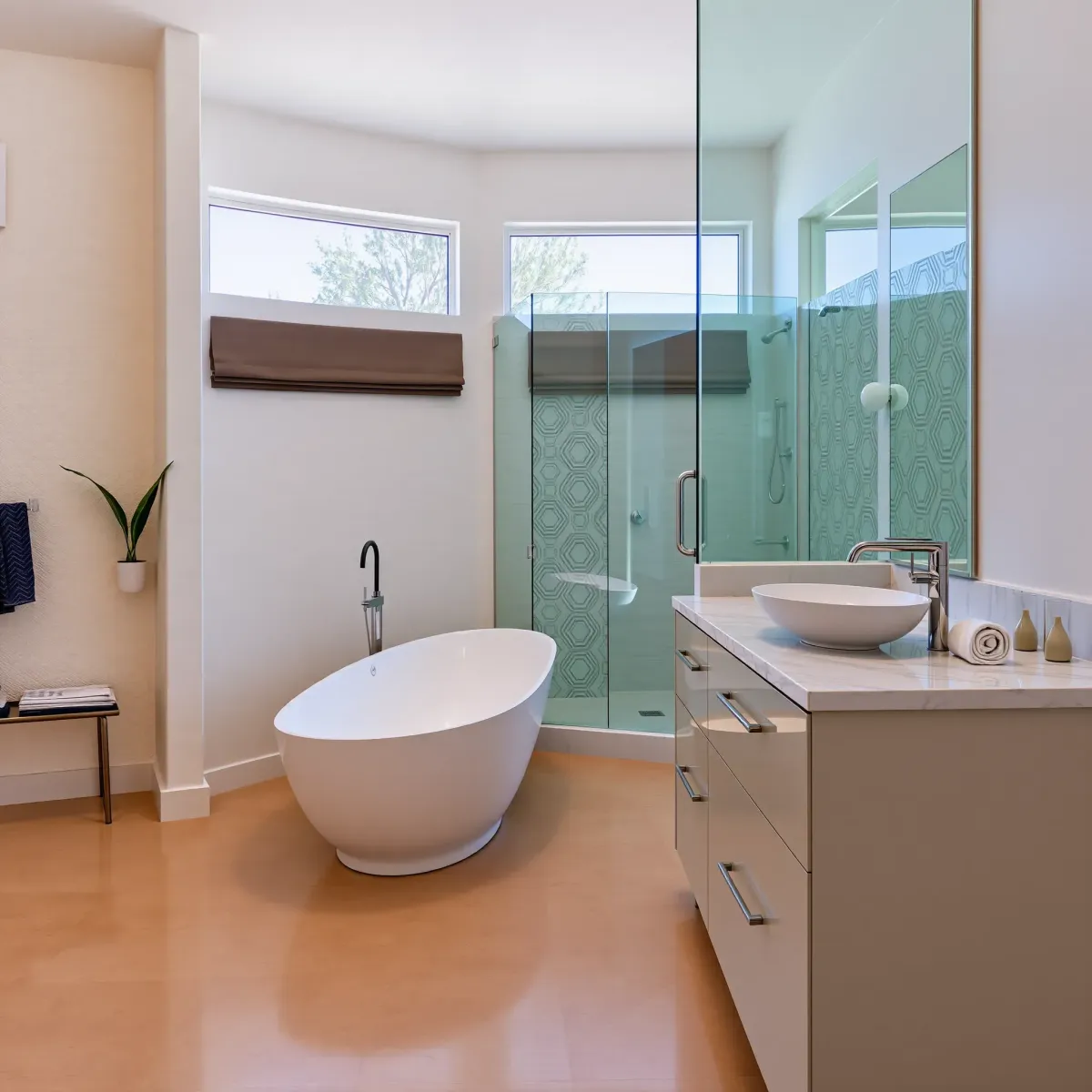 Remodeled Palms, CA bathroom with bathtub, marble vanity, glass shower, lush greenery view, modern design.
