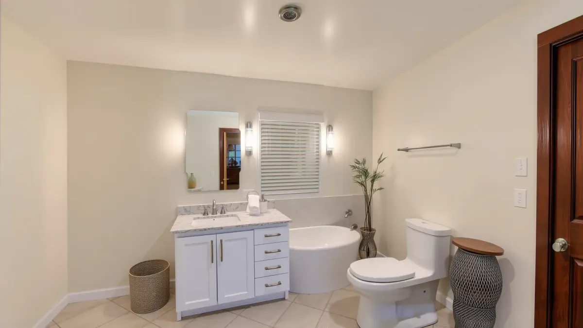 Luxury remodeled Manhattan Beach bathroom with marble floors, soaking tub, frameless shower, ocean view, modern finishes.