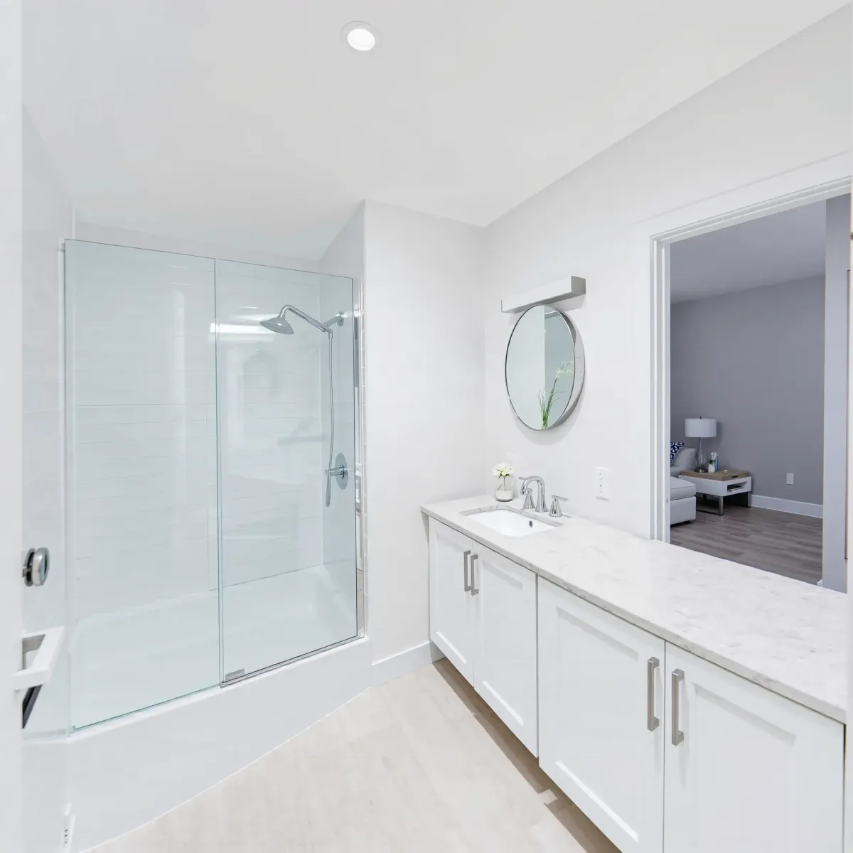 Modern small bathroom in Wilmington, CA with marble tiles, glass shower, sleek fixtures, and natural light.
