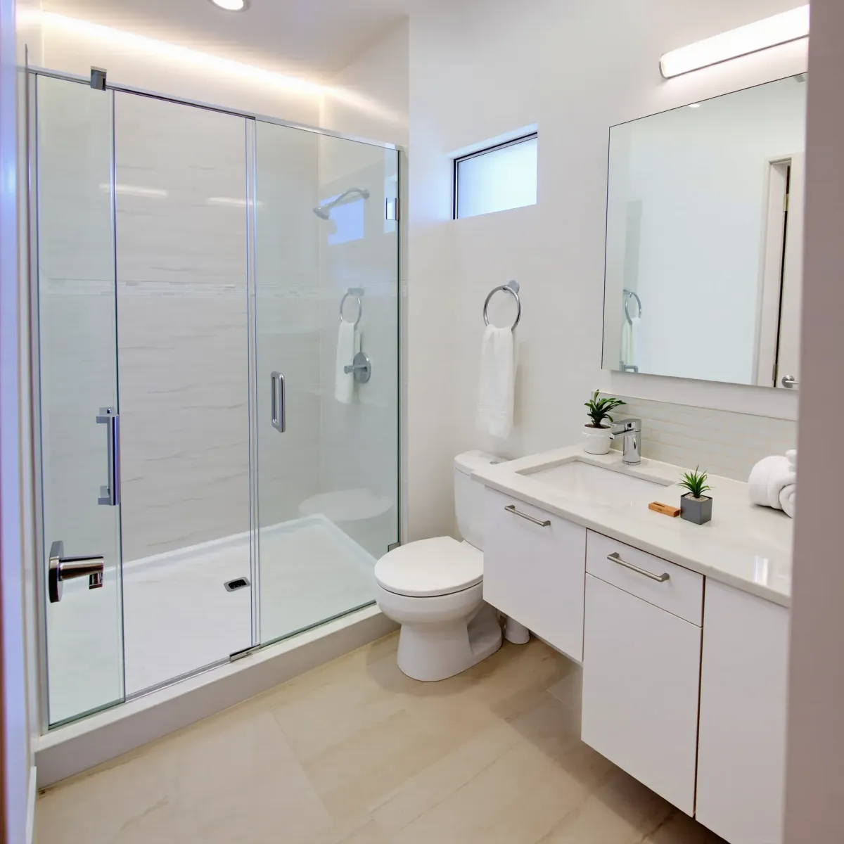 Small modern bathroom in Palms, CA with glass shower, marble vanity, subway tiles, and natural light.
