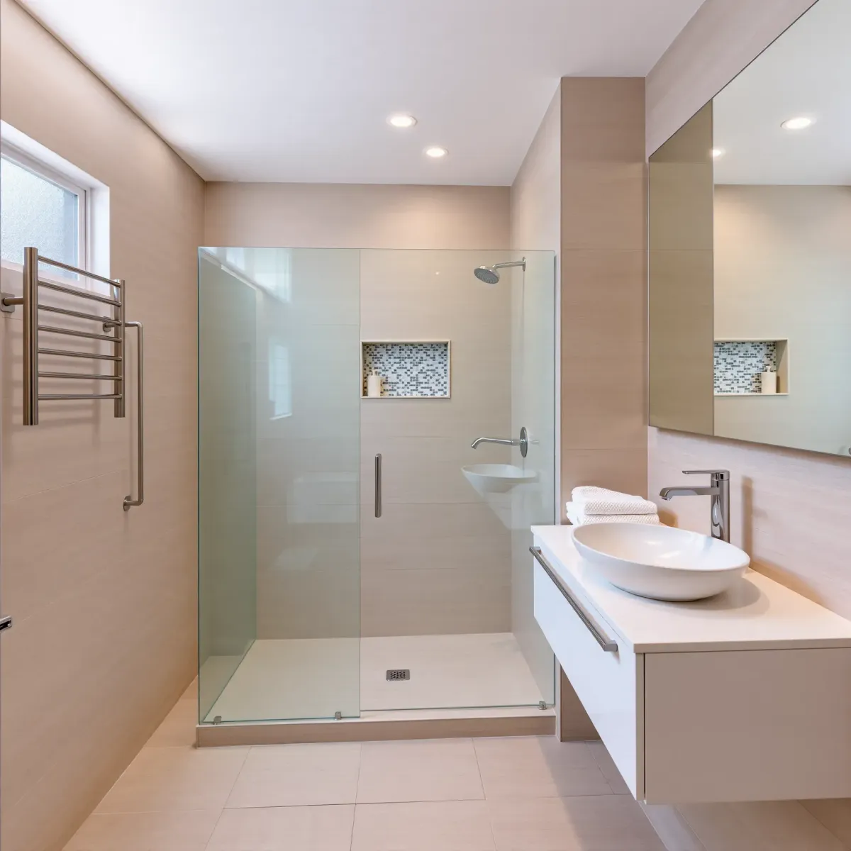 Small Mid Wilshire bathroom with beige tiles, glass shower, floating vanity, large mirror, natural light, modern decor.