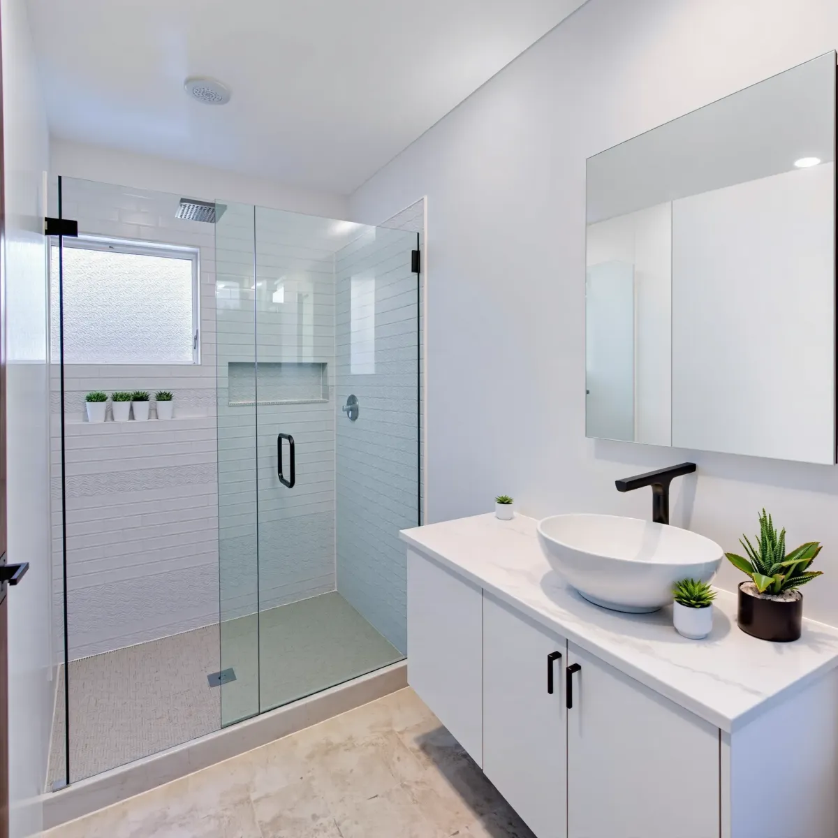 Remodeled Hermosa Beach bathroom with white subway tiles, glass shower, floating vanity, and coastal exterior view.