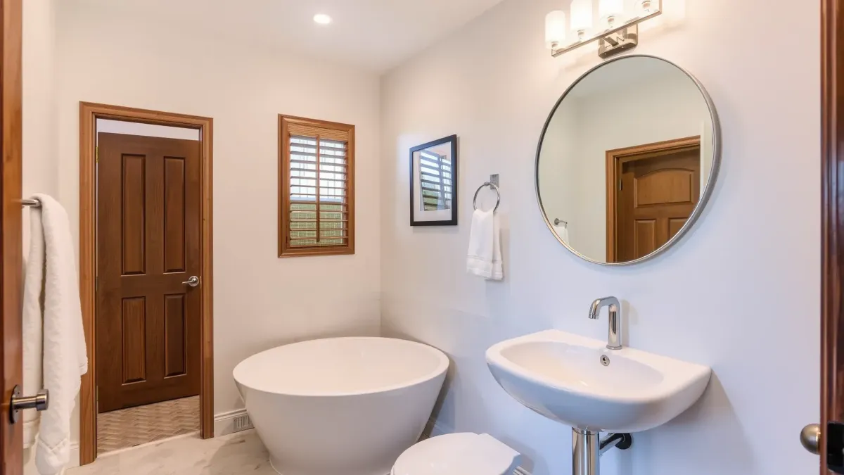 Renovated small bathroom in Mar Vista, CA with modern fixtures, white sink, floating vanity, tile accents, glass shower, and natural light.