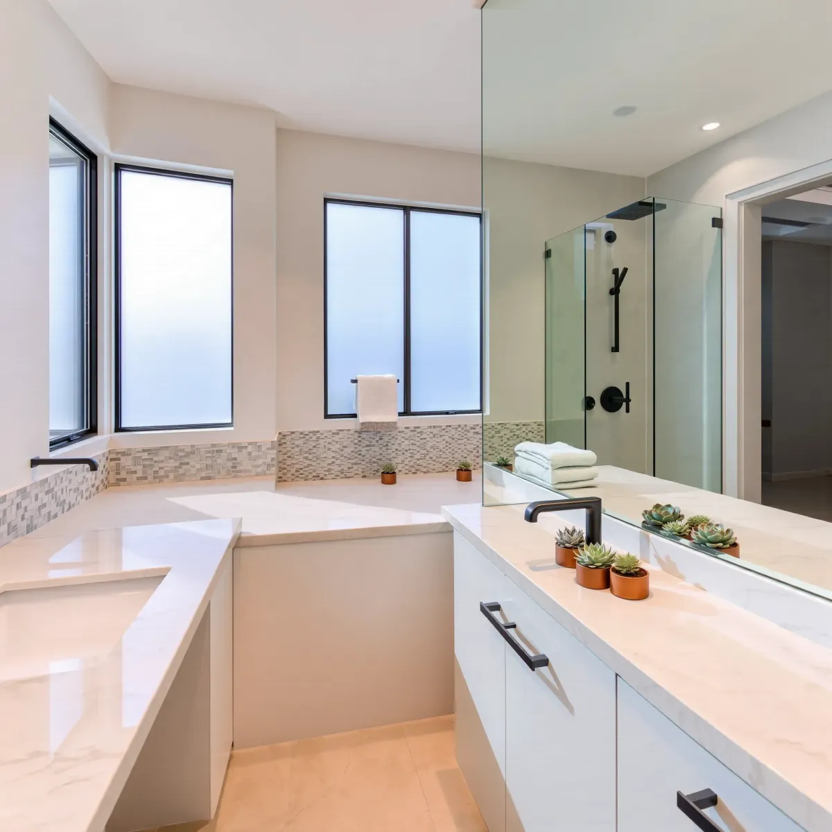 Bright West LA bathroom with sleek modern design, marble countertops, frameless shower, neutral tones, and stylish accessories.