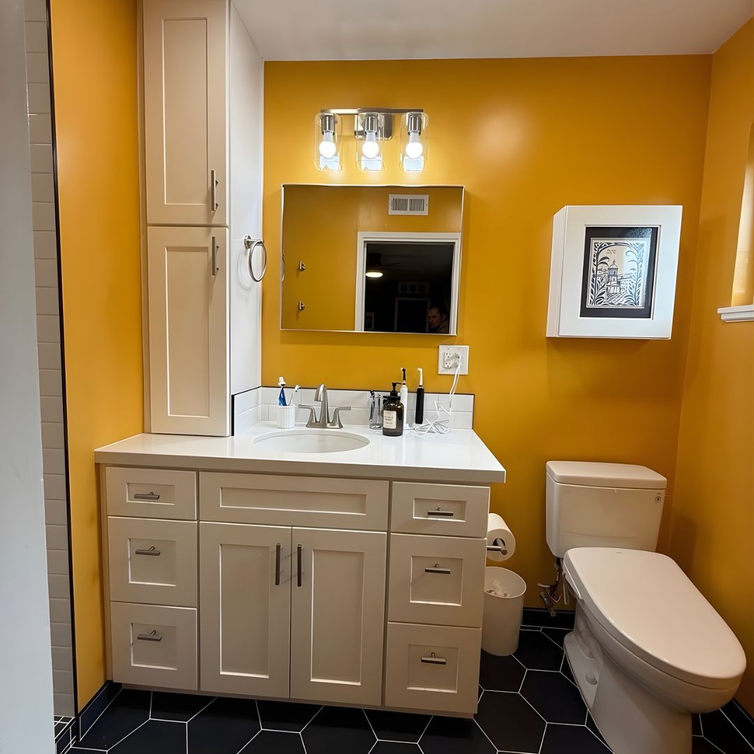 Full bathroom remodel with custom vanity, mustard accent wall, modern lighting, and hex tile flooring
