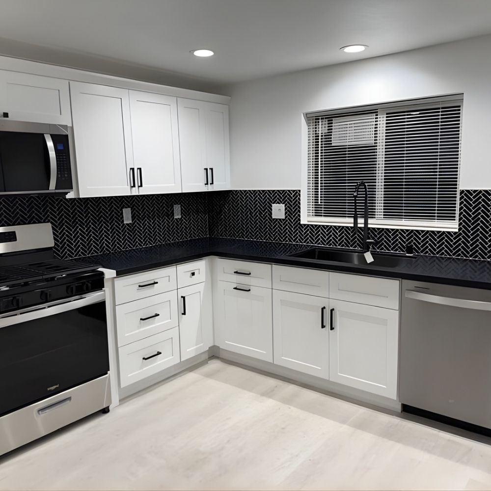 Modern kitchen featuring newly installed stove, dishwasher, and microwave with white cabinetry