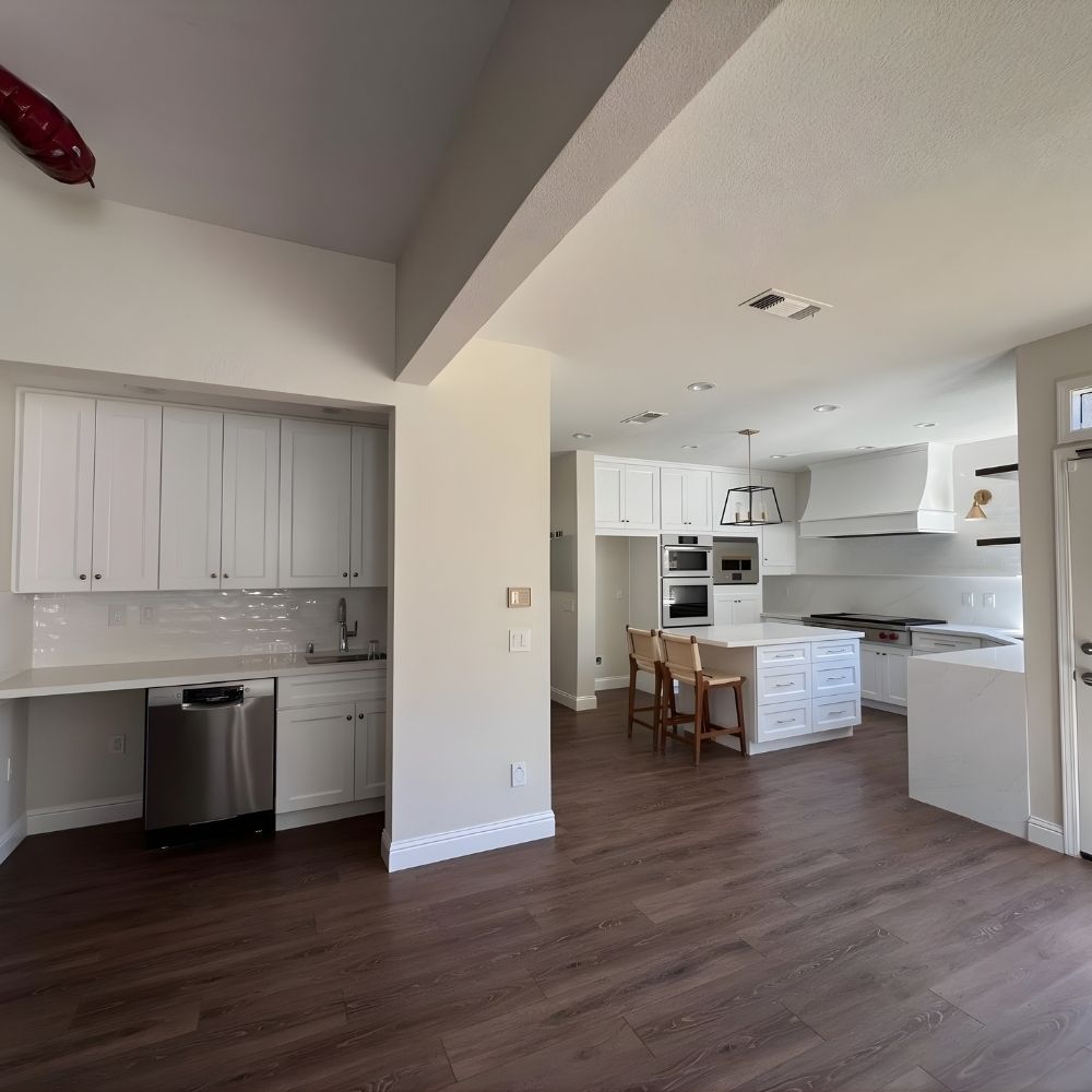 Spacious kitchen remodel with extended cabinetry, open layout, and warm wood flooring