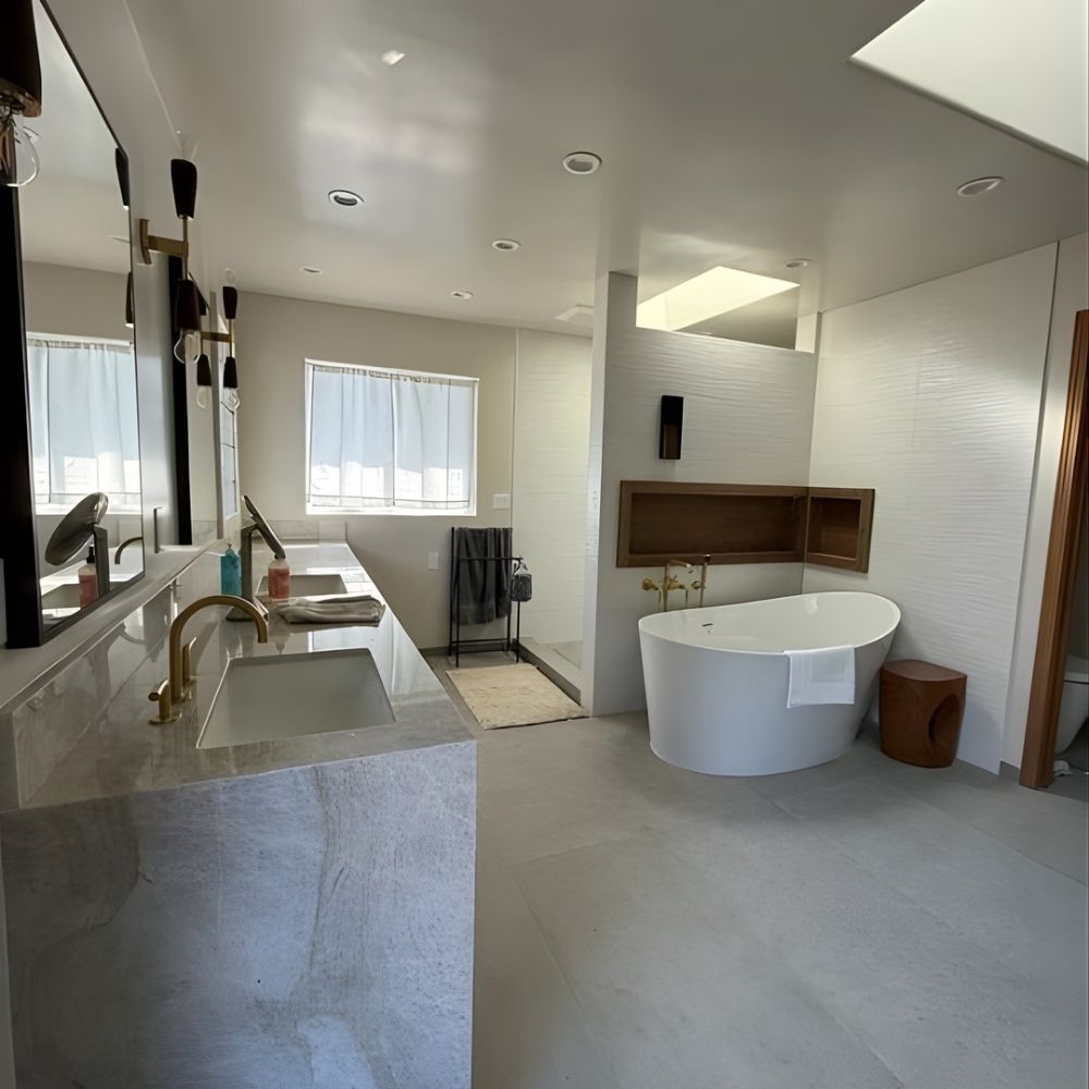 Spa-style bathroom with dual sinks, freestanding tub, natural light, and minimalist finishes