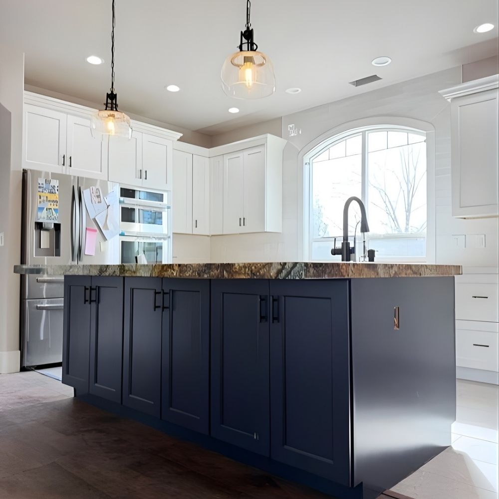 Two-tone kitchen remodel with navy island, gold hardware, and arched window detail