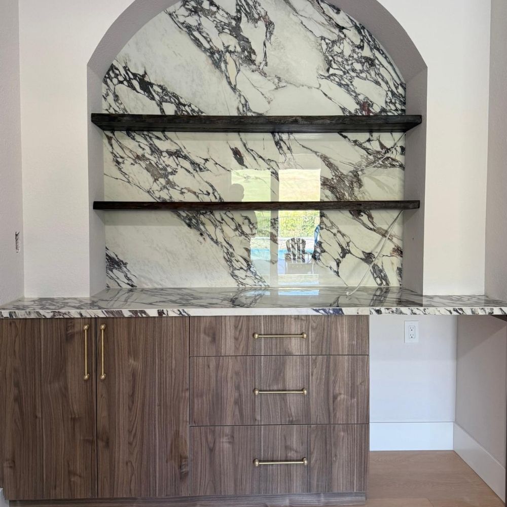 Built-in marble feature wall with open shelving and custom wood base cabinetry