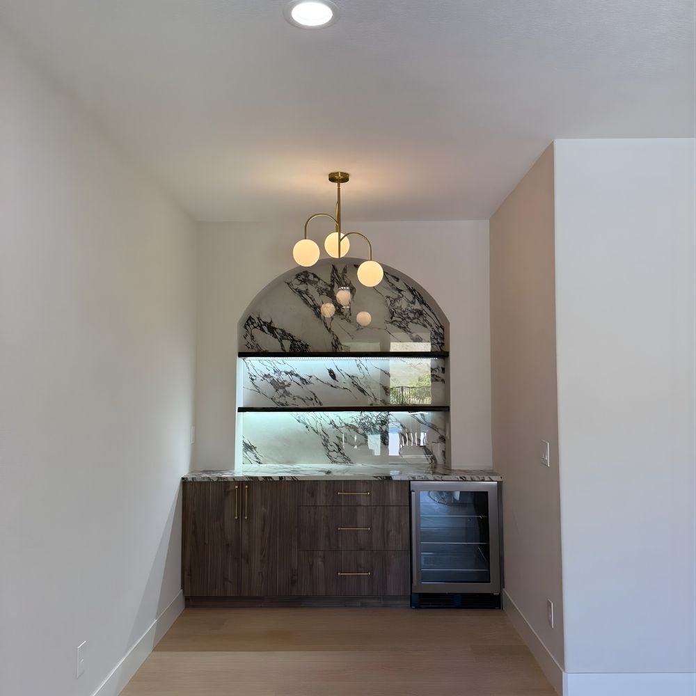 Custom flooring with built-in wood cabinetry, decorative tile backsplash, and modern pendant lighting