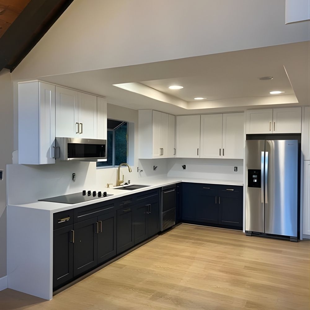 Two-tone kitchen with navy lower cabinets, white uppers, and open floor plan
