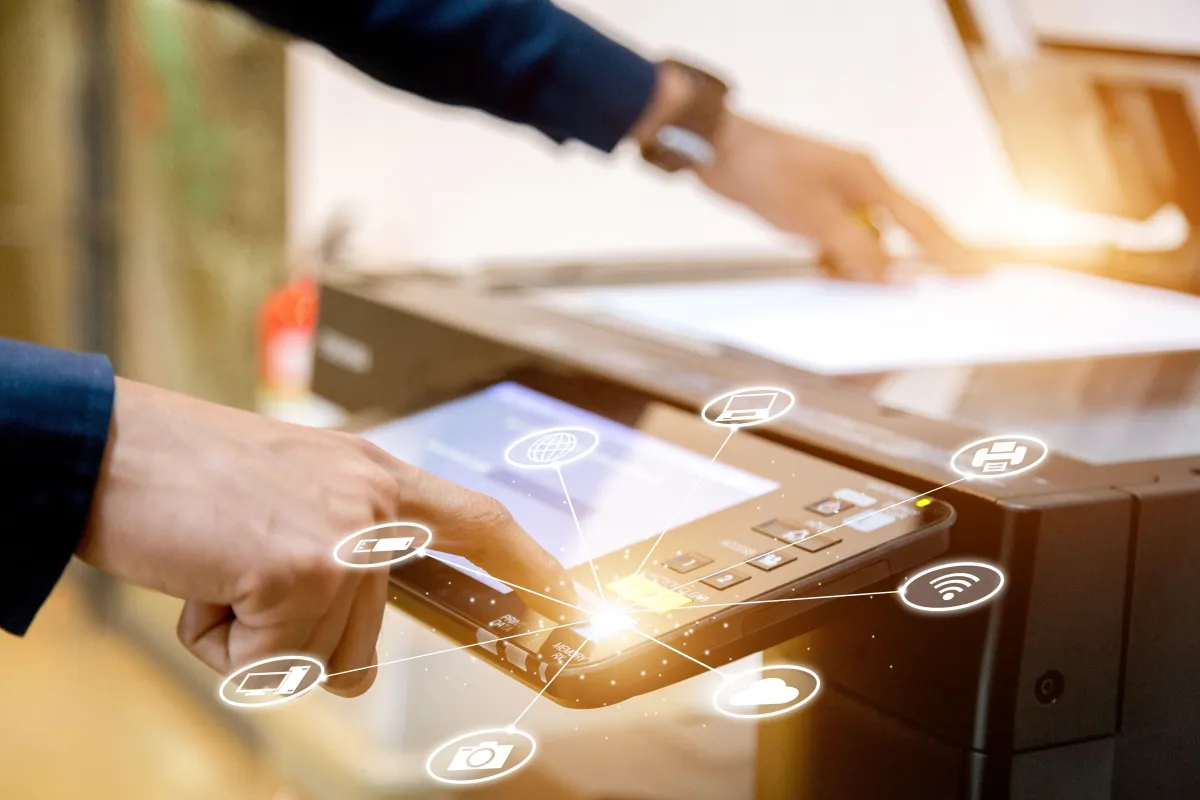 Close-up of a hand using a digital touchscreen interface on a modern office printer