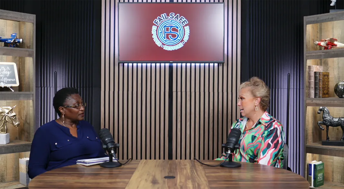 Professional podcast studio with acoustic panels, dual monitors, and a sleek mixing console. A Hispanic woman in headphones is recording, while a South Asian man adjusts audio levels. The room is high-tech, organized, and filled with creative tools.