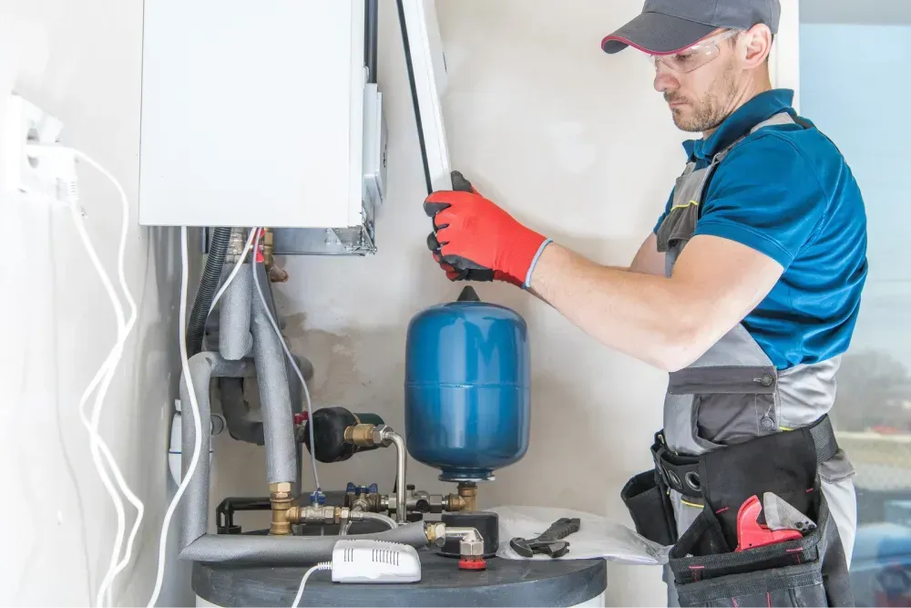 Technician installing new plumbing fixtures and connecting pipes in a residential utility area.