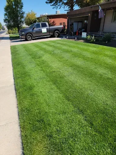 Howard and Family team mowing a front yard during routine weekly lawn care service
