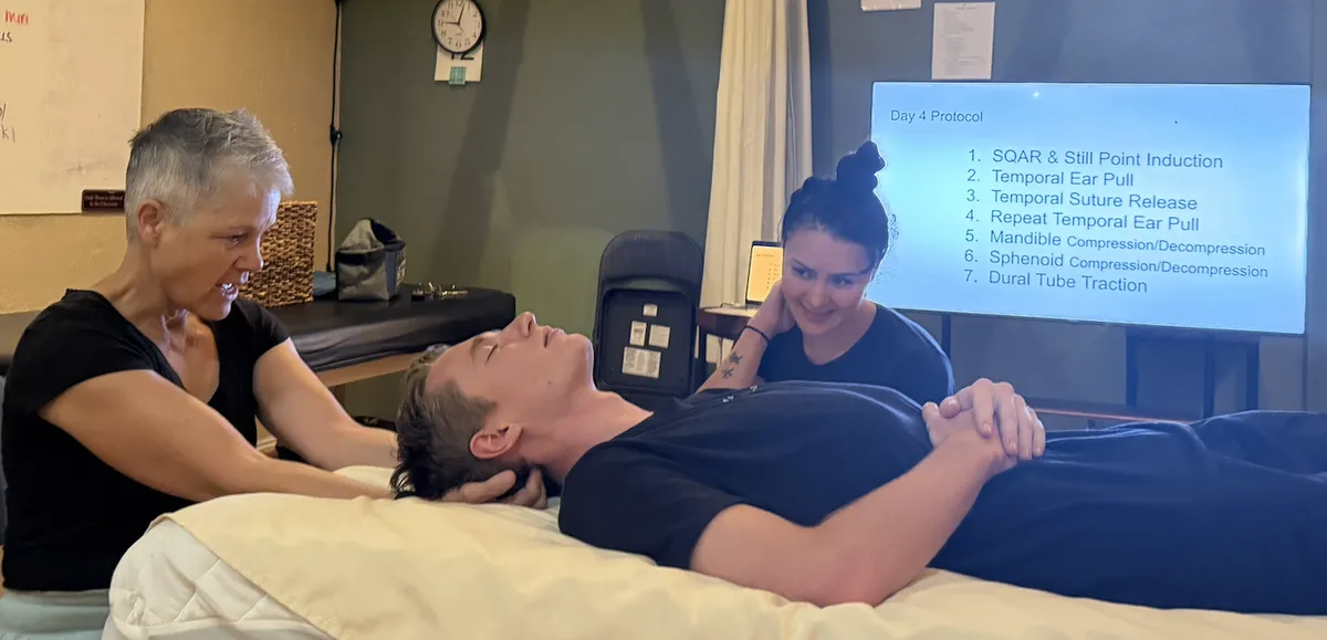 Karey Kosorok demonstrating a CranioSacral Therapy technique on a student during class at Zion Massage College.