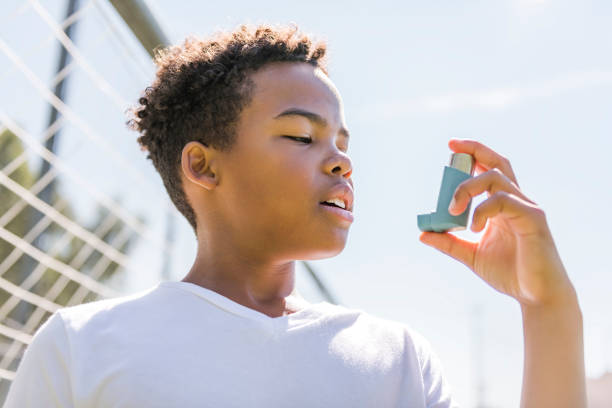 Boy outside using asthma inhaler Wellvibes Limited