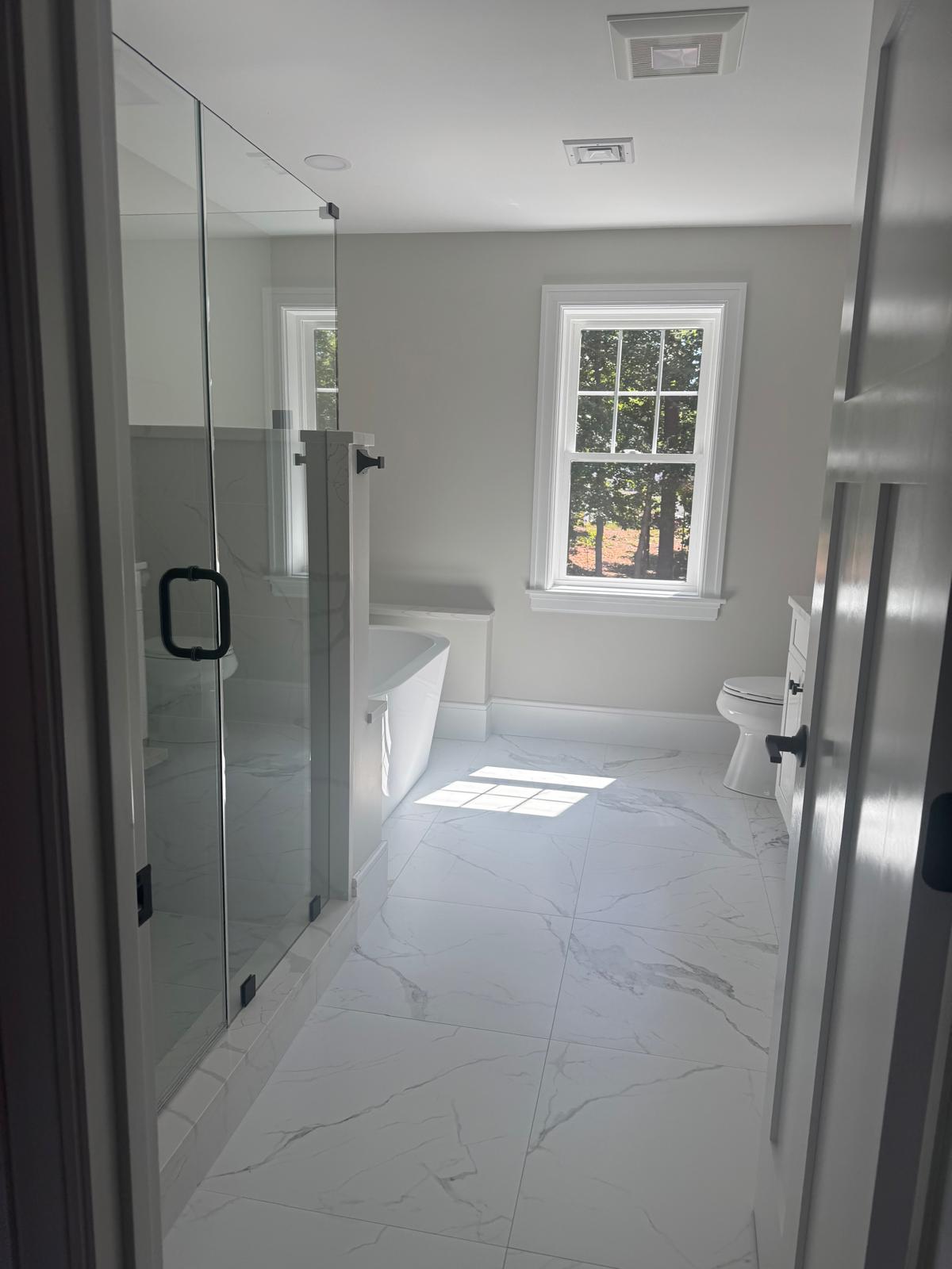 comfort room with white bathtub and brown wooden cabinets