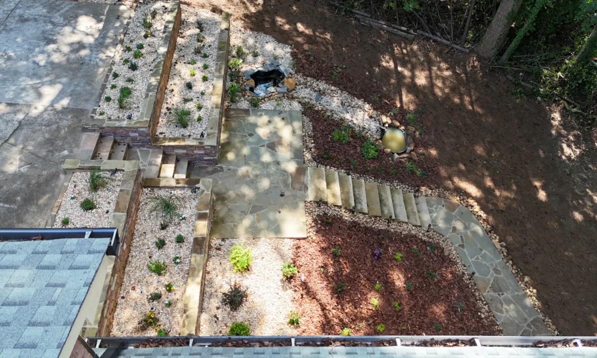Landscaping project stabilizing an eroding hillside with stonework and water feature