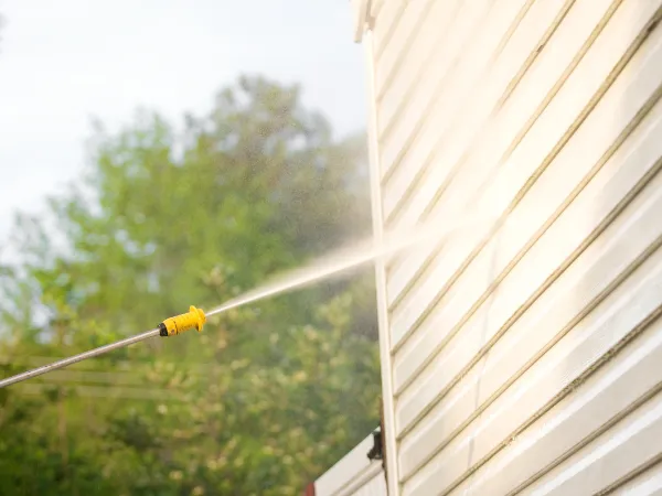  Pressure washing vinyl siding on a residential home exterior