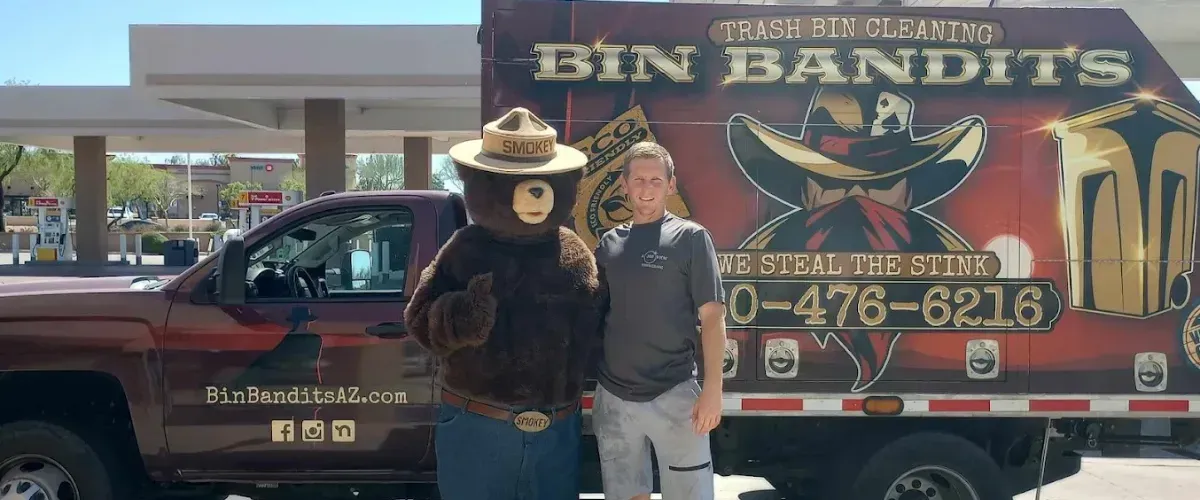  Bin Bandits truck at a gas station with a crew member posing next to Smokey Bear.