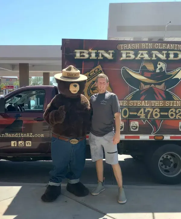 Bin Bandits cleaning truck with a person posing beside a bear mascot