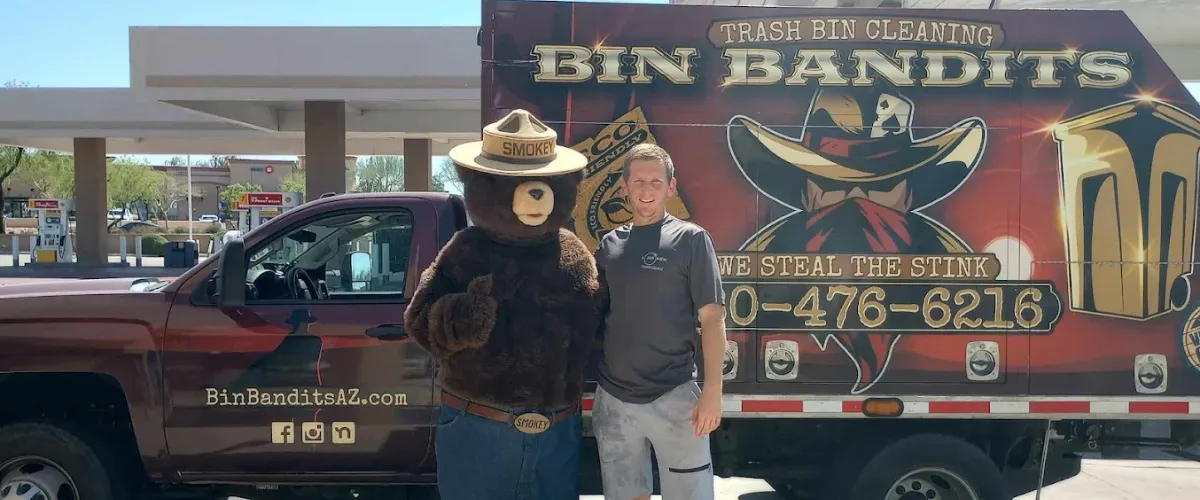 Bin Bandits truck with Smokey Bear mascot and technician promoting sanitation services