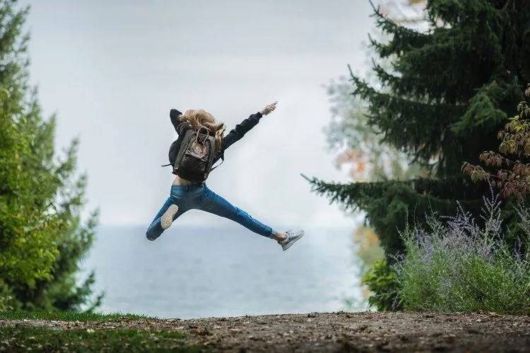 A woman jumping in the air with her arms outstretched