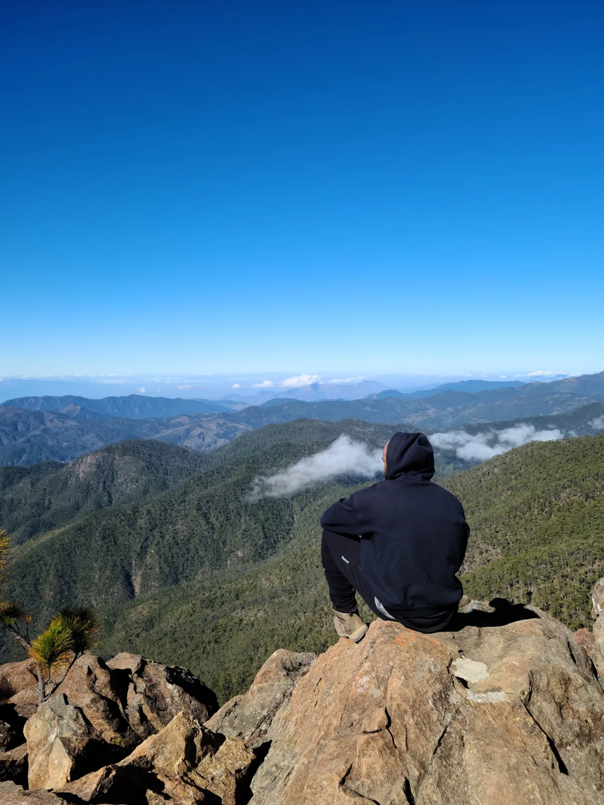 man sitting at the top of Peco Duarte