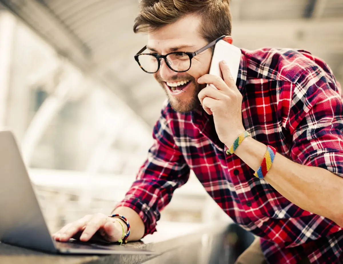 freundlicher Dachs teleoniert und arbeitet am Laptop