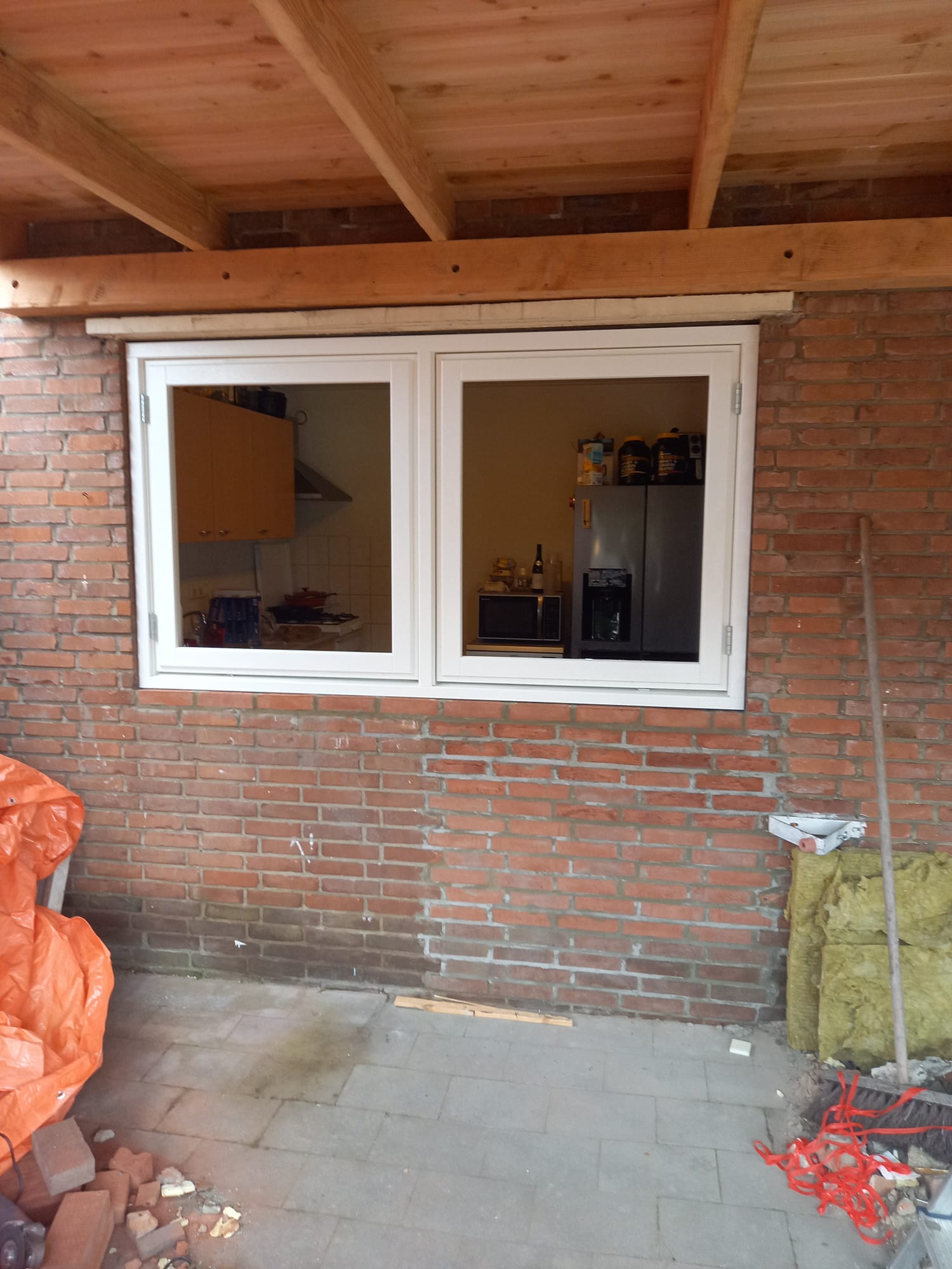 Gevelrenovatie in Veenendaal waarbij een oude deur is vervangen door twee draaikiep-ramen en vakkundig dichtgemetselde spouwmuur door IMT Bouwservice.