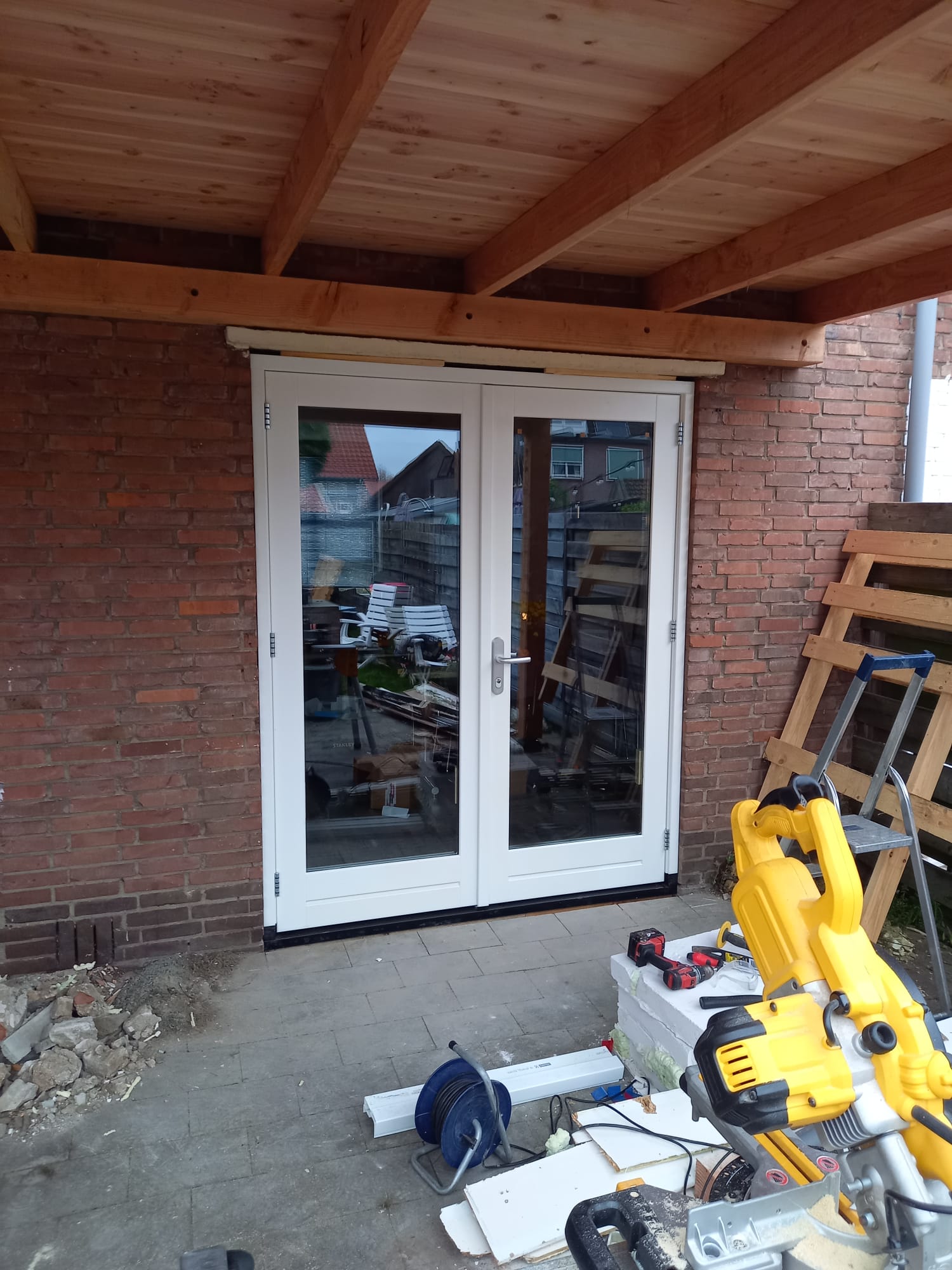 Hardhouten openslaande tuindeuren en een maatwerk Douglas overkapping geplaatst in Amersfoort door IMT Bouwservice.