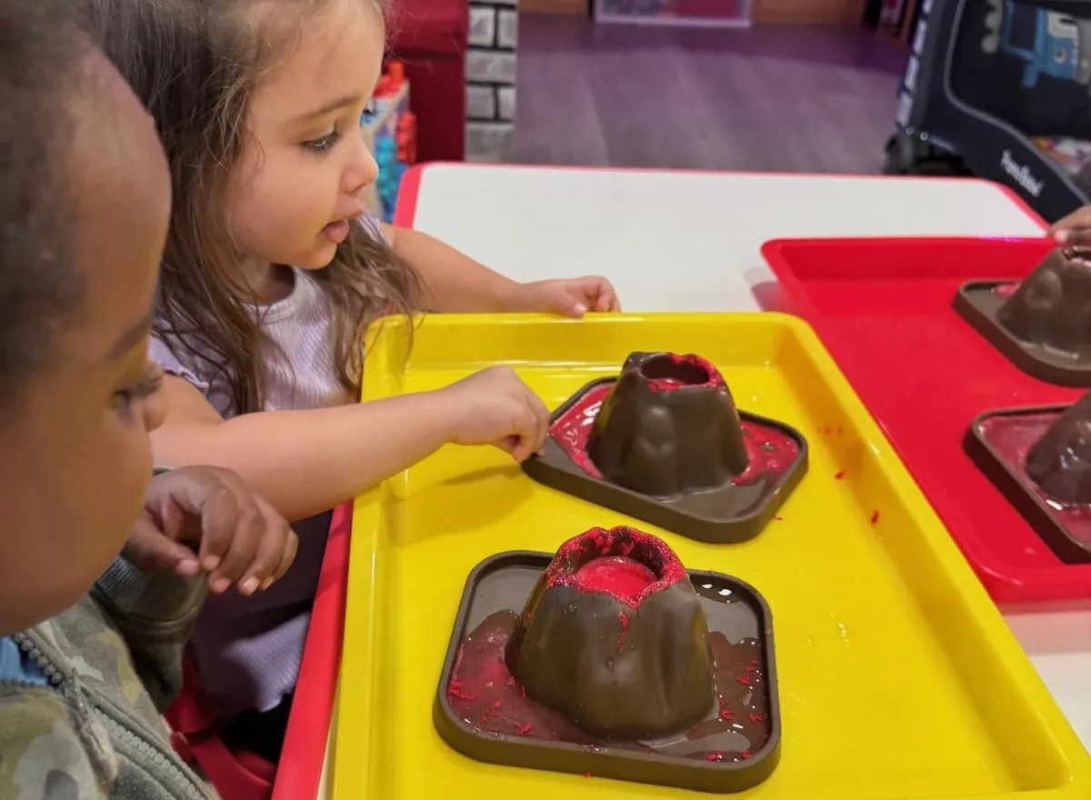 Boy picks paper out of different colored liquids