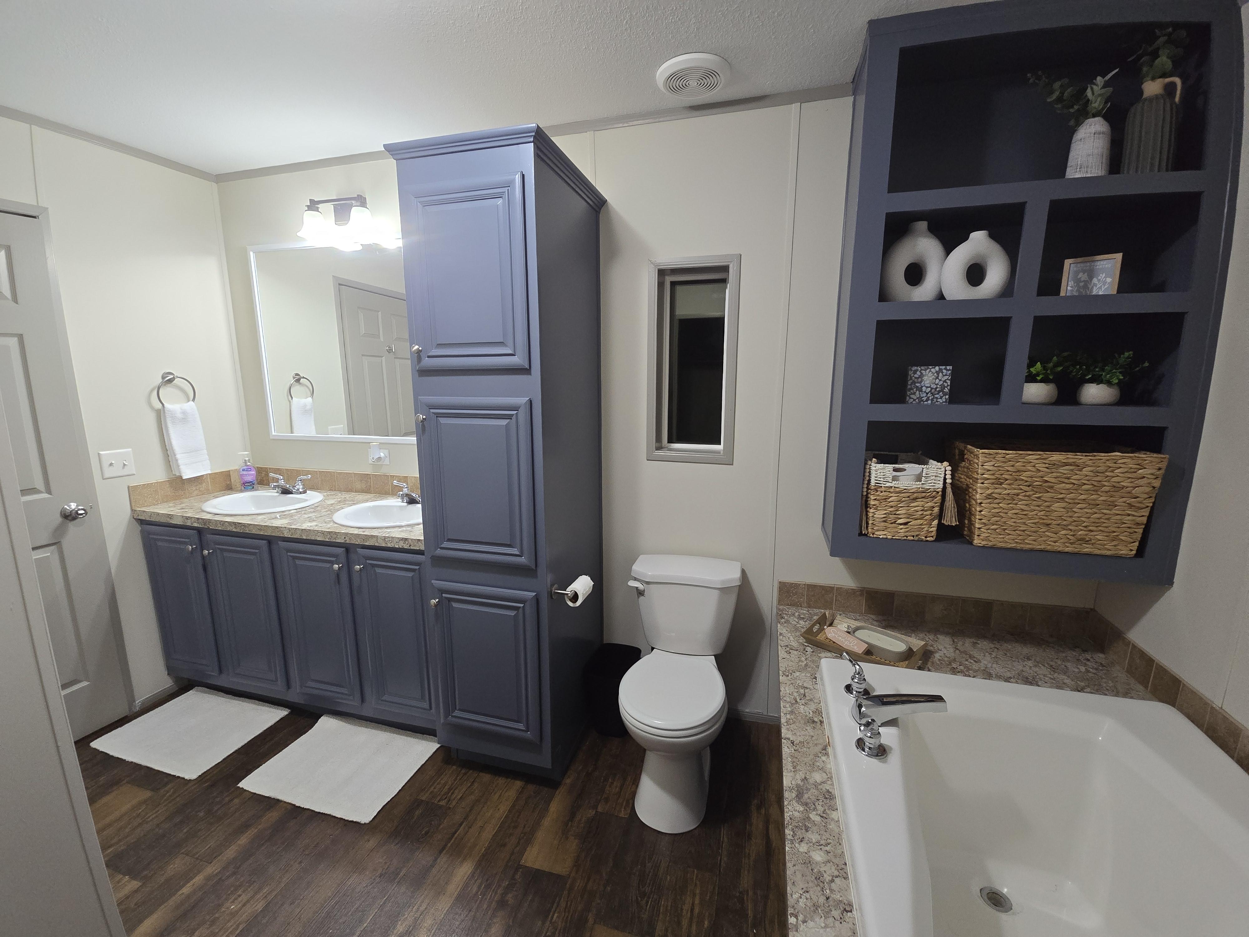 A modern kitchen with navy blue cabinets, light gray walls, and a glossy, easy-to-clean finish, demonstrating a specialty coating application.