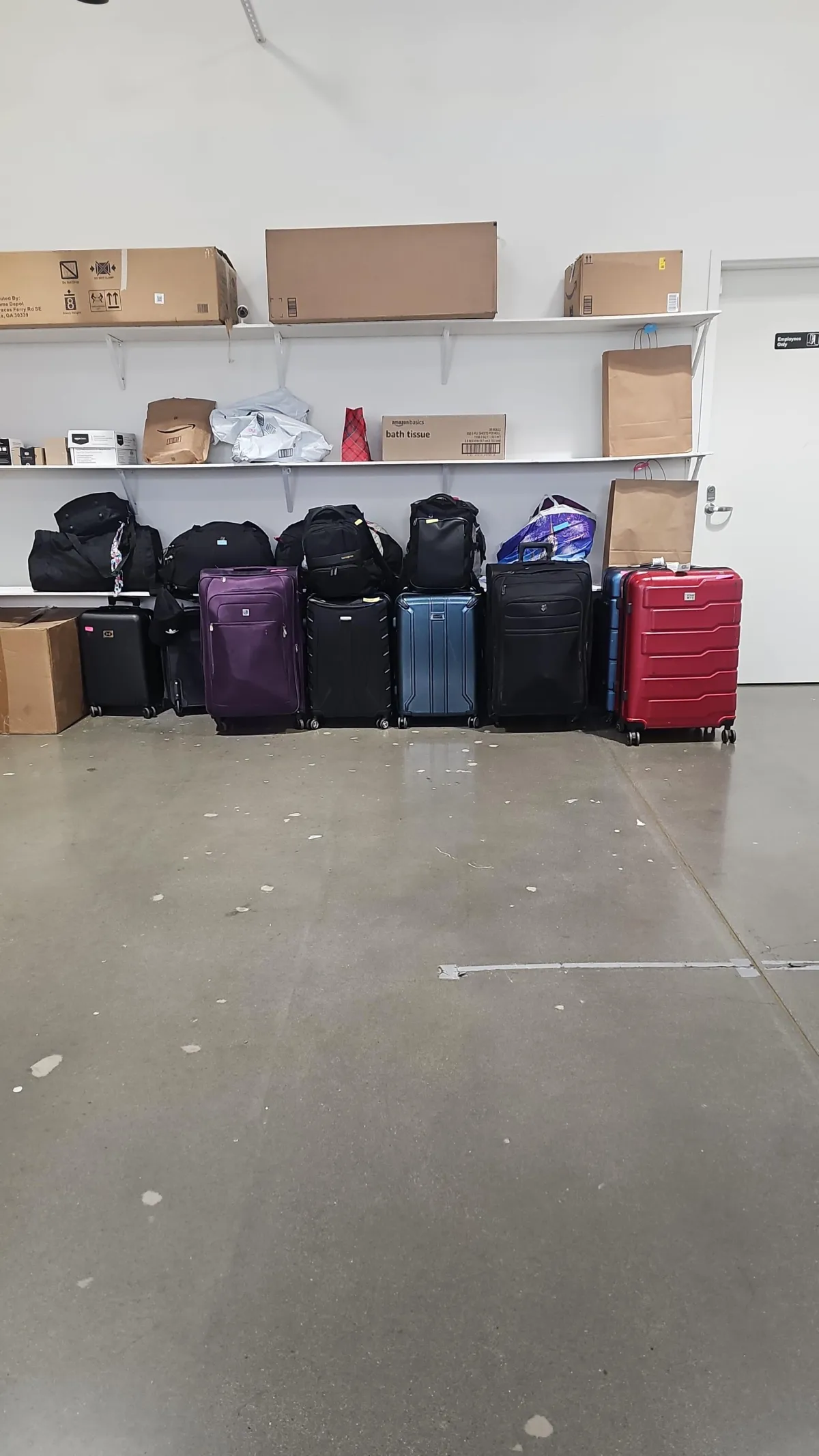 a woman standing next to two suitcases in front of a mural