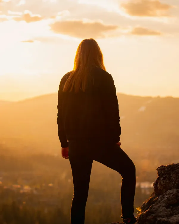 Woman standing on a hilltop overlooking the landscape below