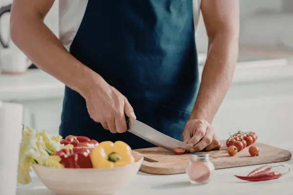 Person preparing healthy meal with Grip Hydra nearby, showing sustainable approach vs. restrictive crash diet (balanced, healthy - diverse)