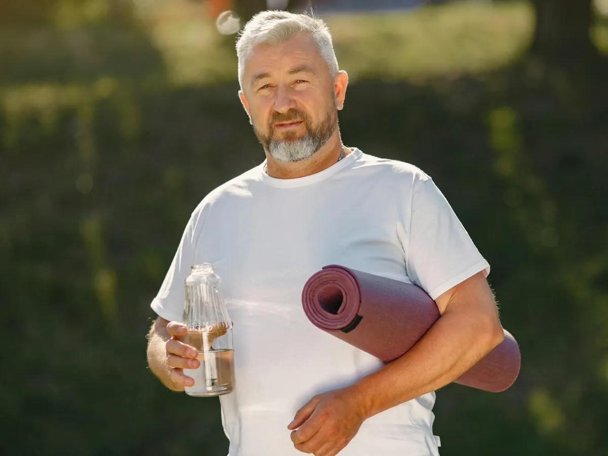 Man with a yoga mat and a bottle of water