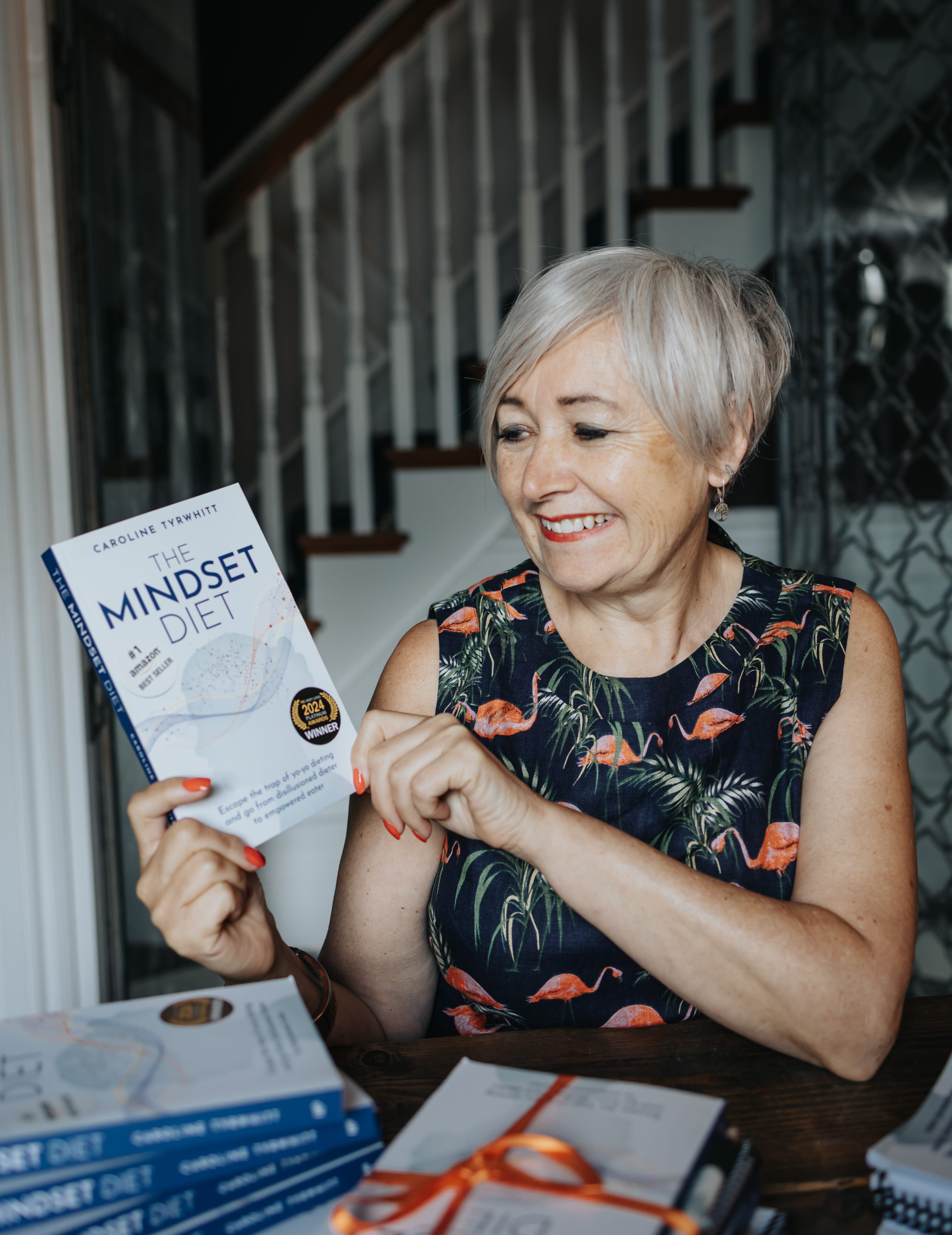Caroline Tyrwhitt holding The Mindset Diet book
