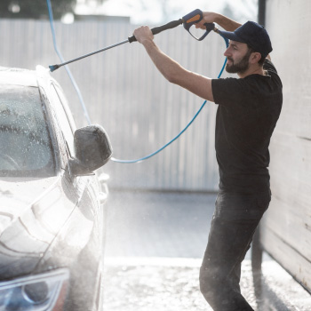 Man spraying off top of car