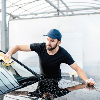 Man wiping off front windshield