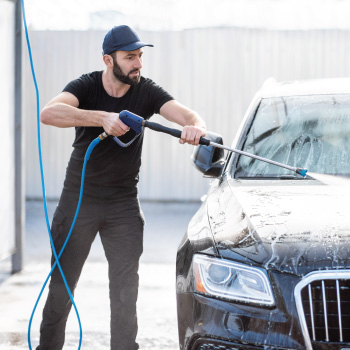 Man spraying off hood of car
