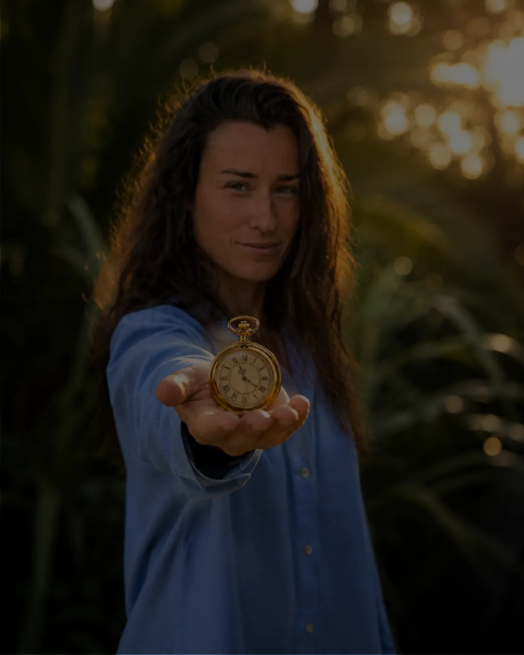 A person holding a vintage pocket watch in their palm.