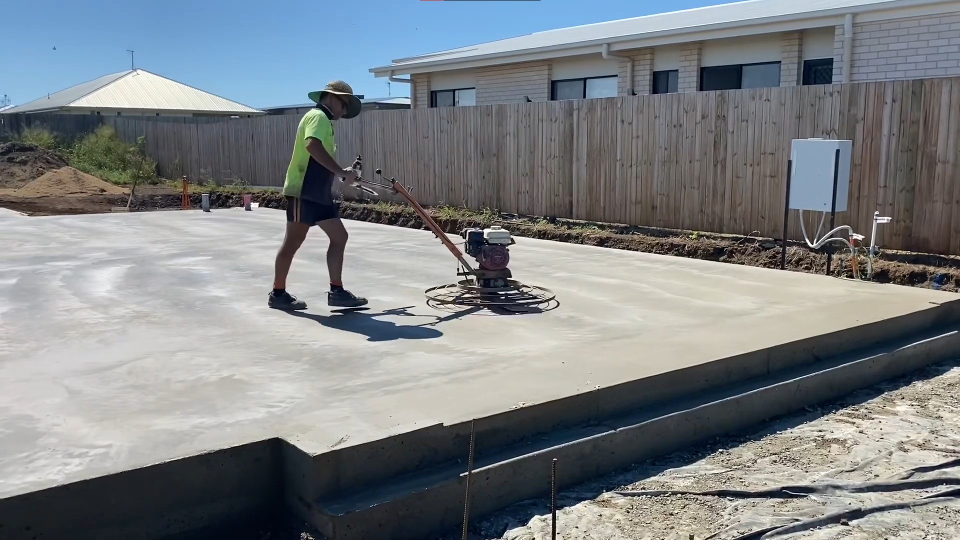 tradie using power trowel to smoothen concrete slabs