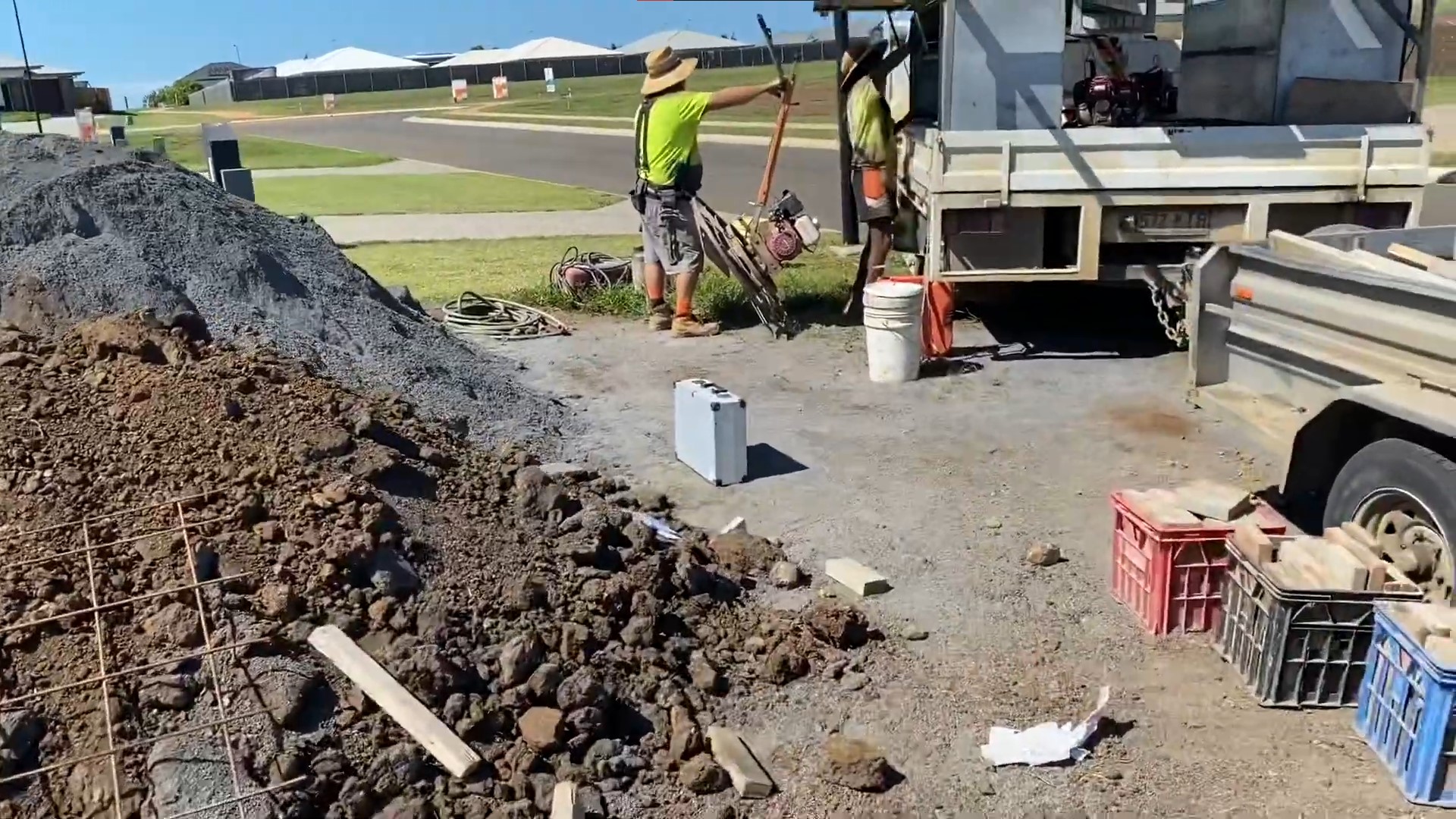cement, gravel, concrete mix on the side with tradies loading concrete equipment on truck