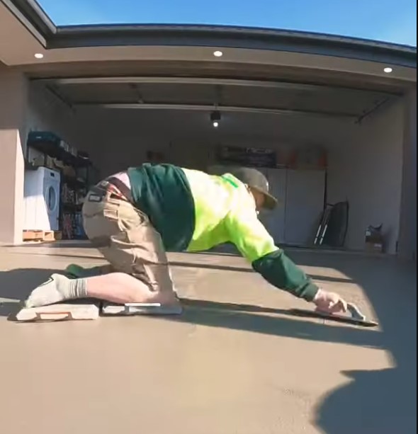 tradee using trowel to give concrete driveway a smooth finish