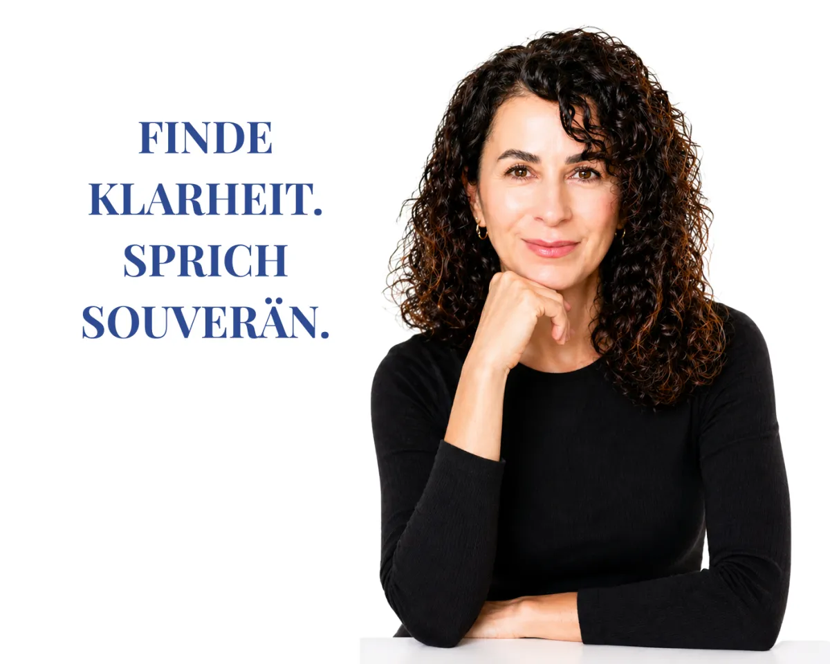 A professional woman in a modern charcoal blazer, looking directly forward with calm, determined focus.